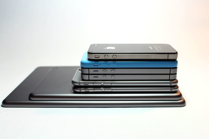 A stack of historical Apple phones and tablets